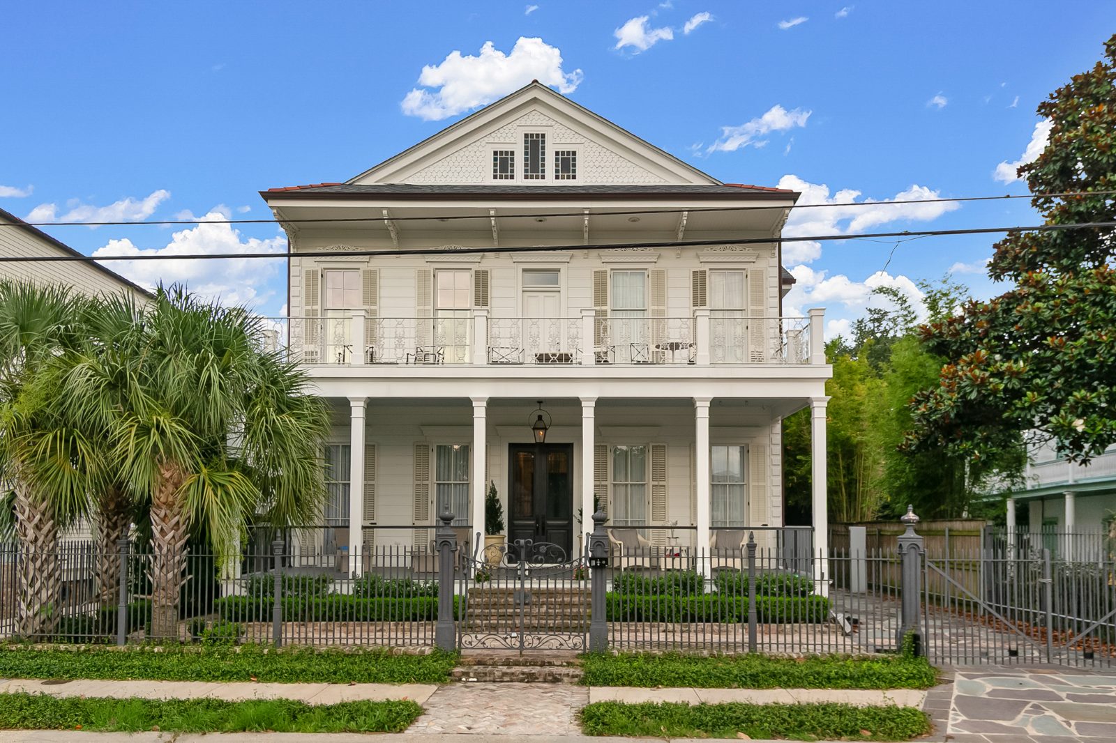 Classic Louisiana home with a deep front porch and iron fencing